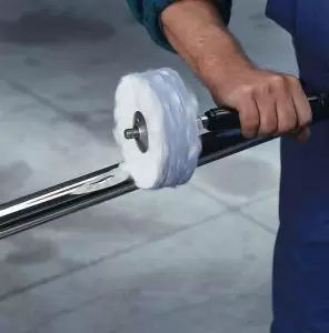 فردی در حال پرداخت سطح فولاد ضد زنگ 